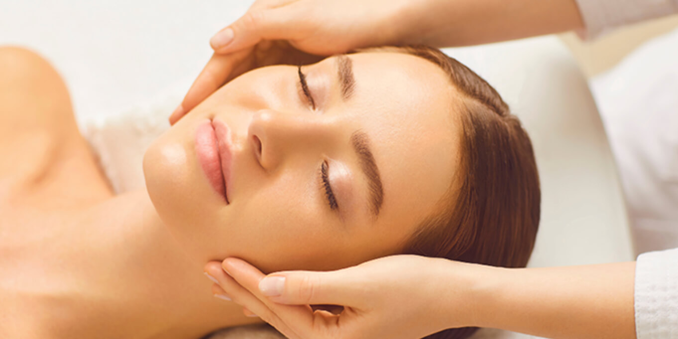 顔にマッサージをしてもらっている女性