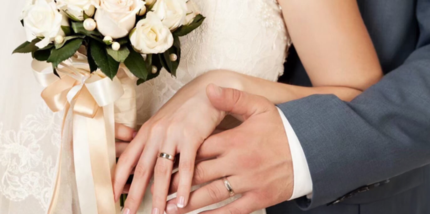 指輪をしている男女が手を取り合っている