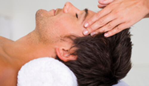 こめかみ辺りをマッサージされている男性