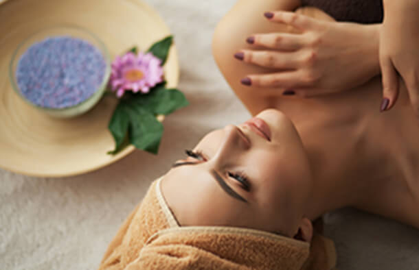 仰向けで横になり、胸に手を当てながら天井に目を向けている女性