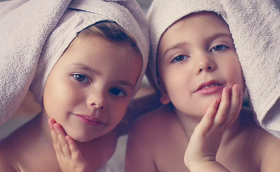 子ども二人がタオルを頭に巻き、手をあごに添えている